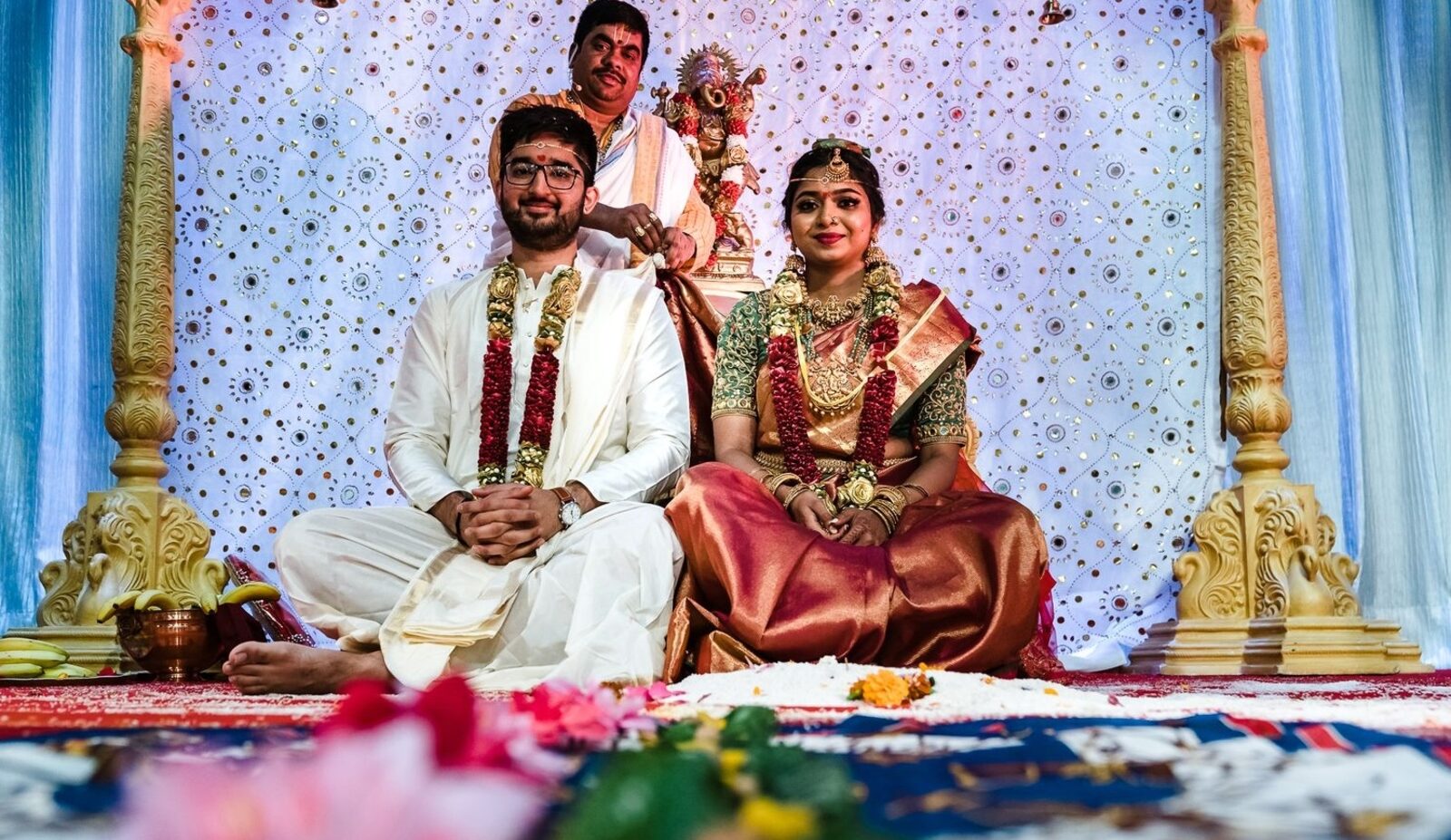 South Indian bride and groom seated at the mandap during their wedding ceremony