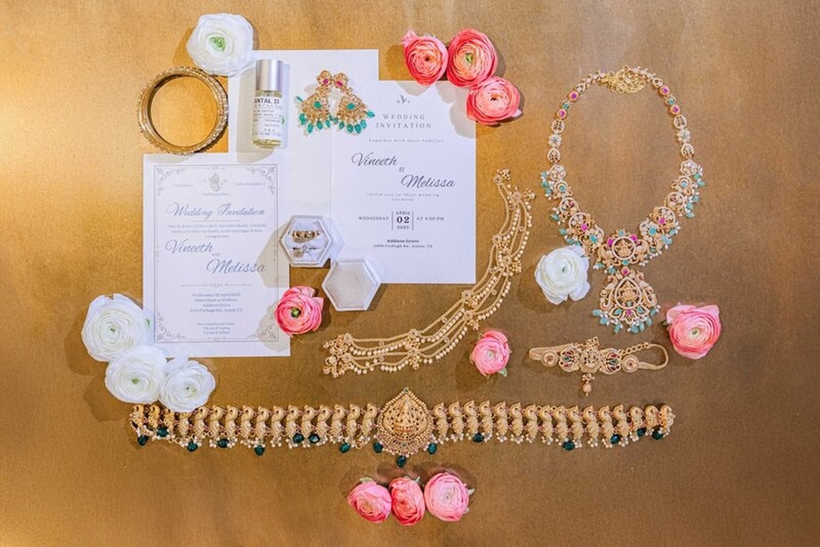 Invitation suite and bridal jewelry on gold backdrop