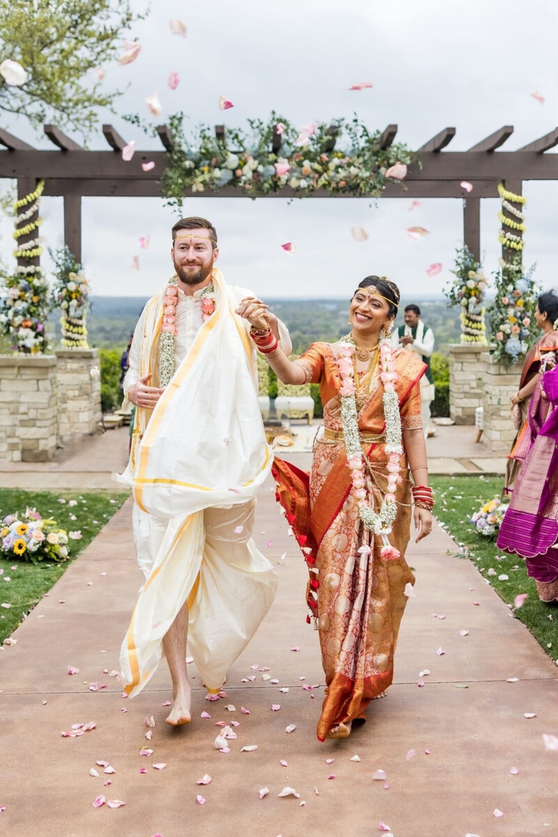 Bride and groom walking down a floral aisle after their wedding ceremony
